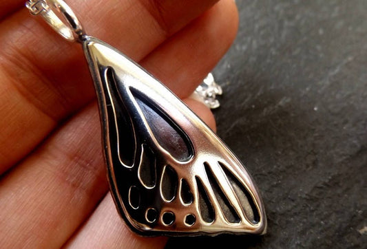 Silver Butterfly wing necklace pendant with oxidized background